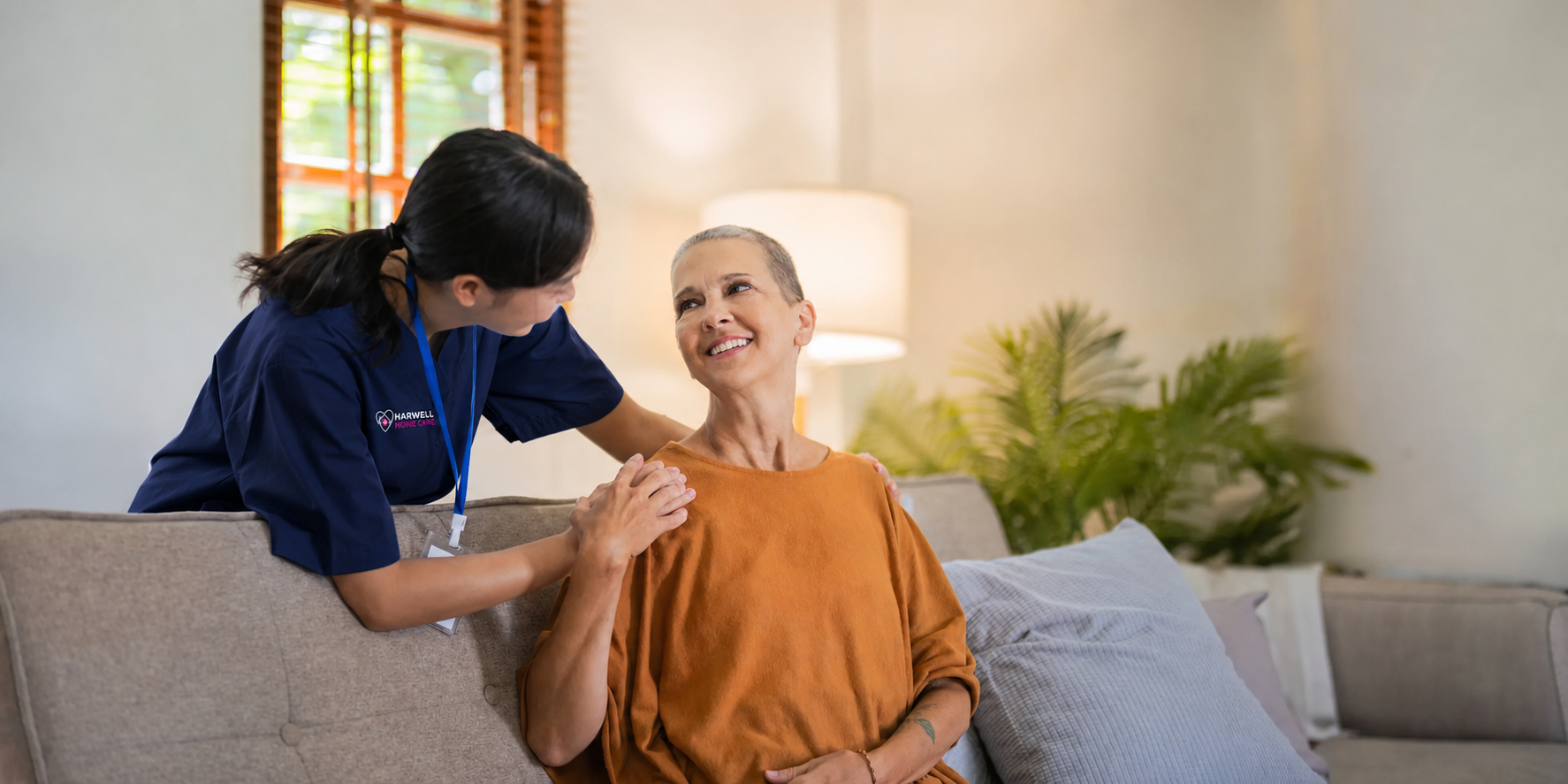 Harwell Home Care nurse in navy scrubs supporting a senior client in her home.