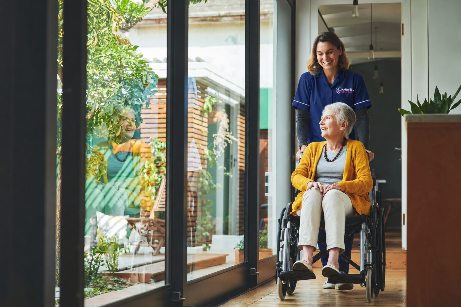 Harwell Home Care worker supporting a senior woman using a wheelchair at home.
